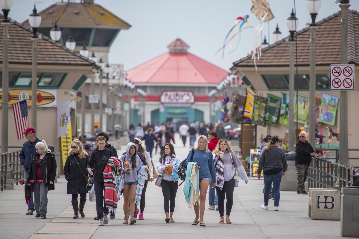 People walk on the  Huntington Beach pier 