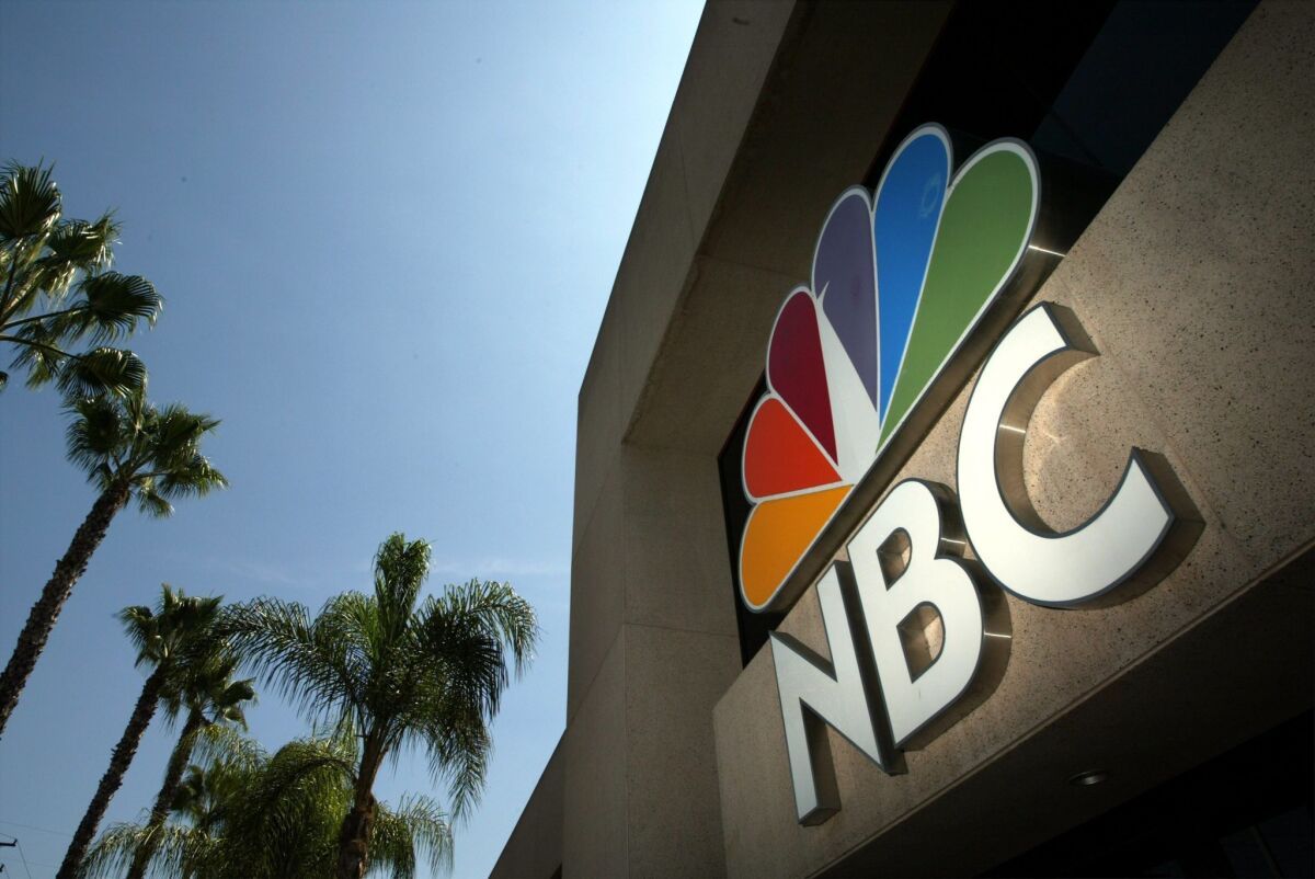 The NBC peacock logo can be seen on the former NBC Studios building in Burbank in 2003. NBC has threatened a blackout this weekend if Dish Network fails to strike a deal with it.