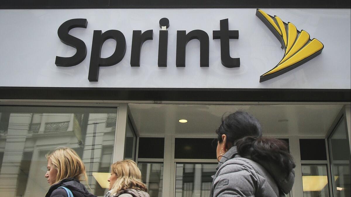 People walk past a Sprint store in 2018.