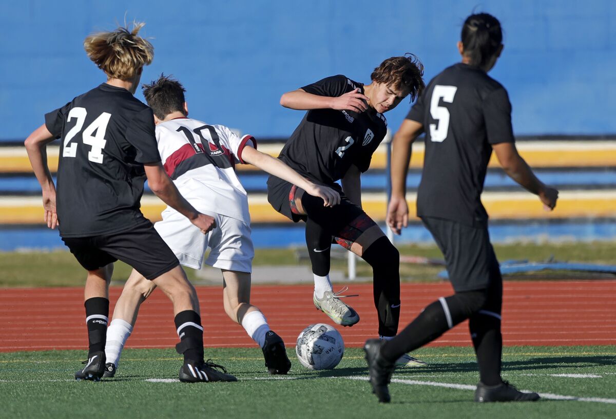 Marina's Keagan Luzadder (2) and Laguna Beach's Julian Riechel mix it up in the corner during a boys' soccer game on Friday.