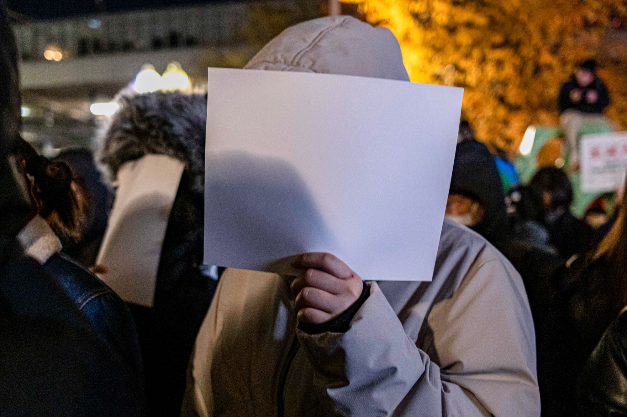 Göstericiler yüzlerinin önünde boş beyaz kağıtlar tutuyor 
