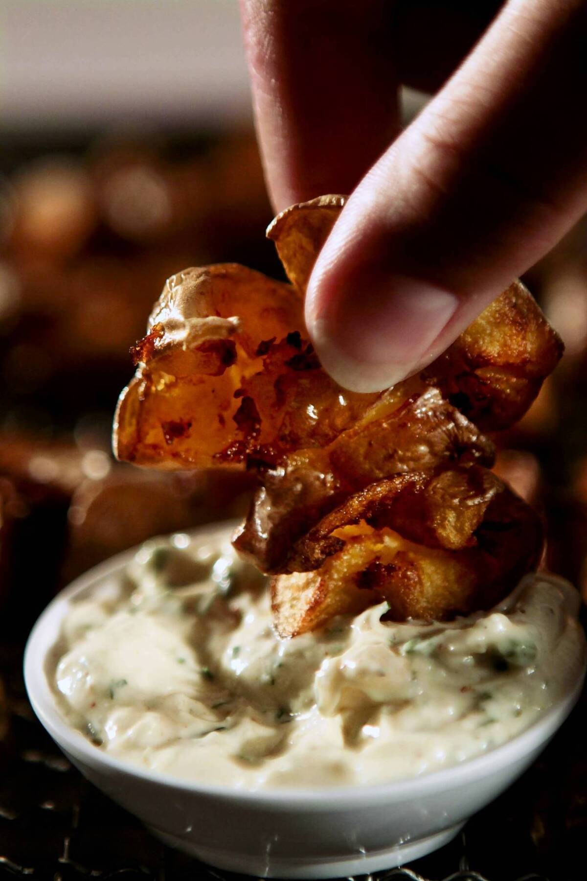 Smashed fried potatoes with creamy ranch dipping sauce.