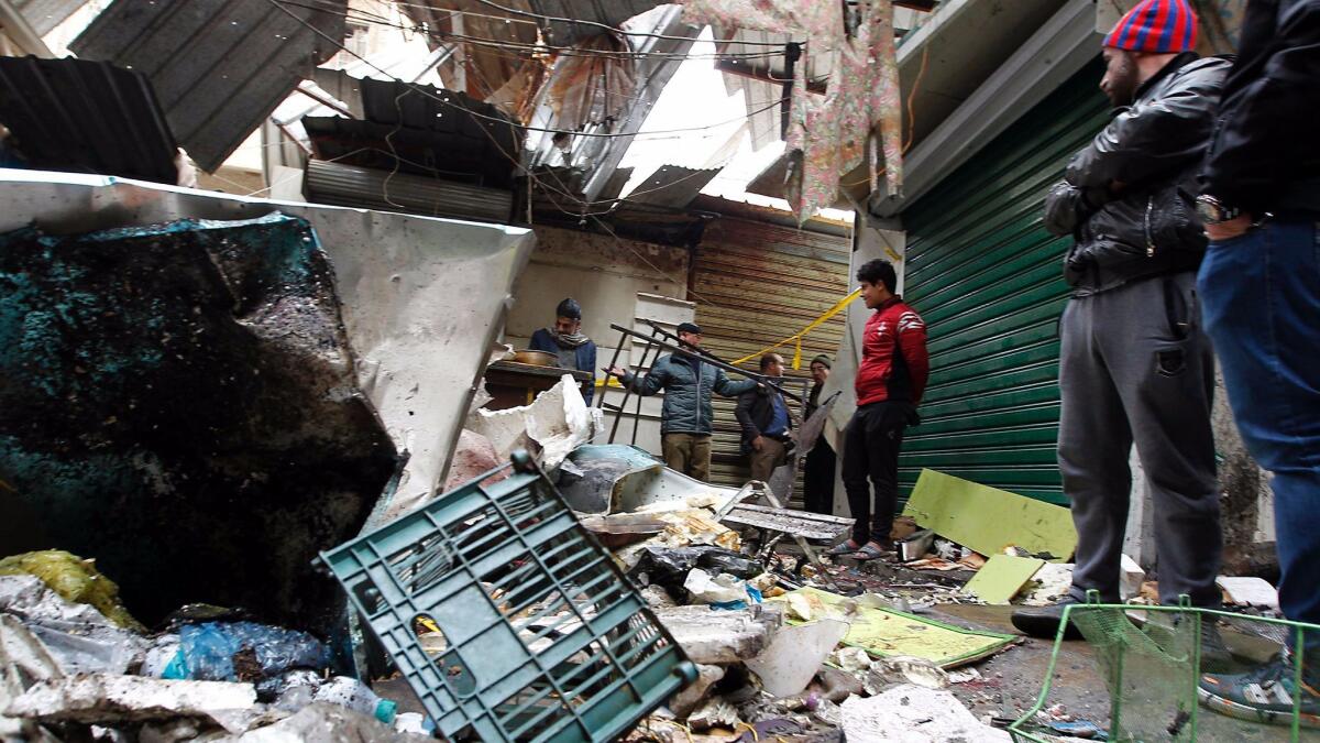 Iraqis observe the aftermath of a double blast in a busy Baghdad market.