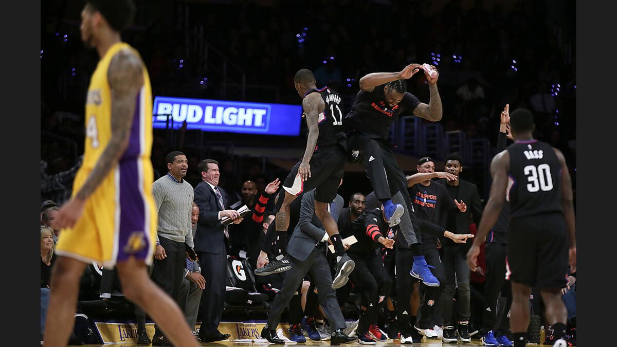 Clippers center DeAndre Jordan greets teammate Jamal Crawford with a bump in the air after Crawford hit a long three-pointer to end the third quarter against the Lakers.