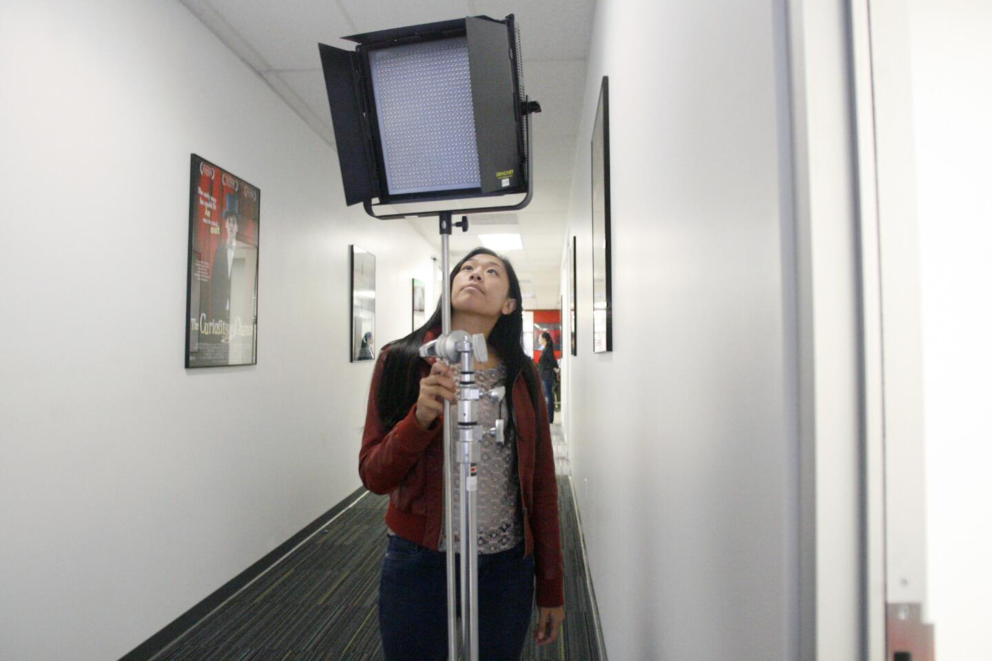 Alyssa Aguilos, 18, takes a look at a light before class at International Academy of Film and Television in Burbank on Wednesday, July 18, 2012.
