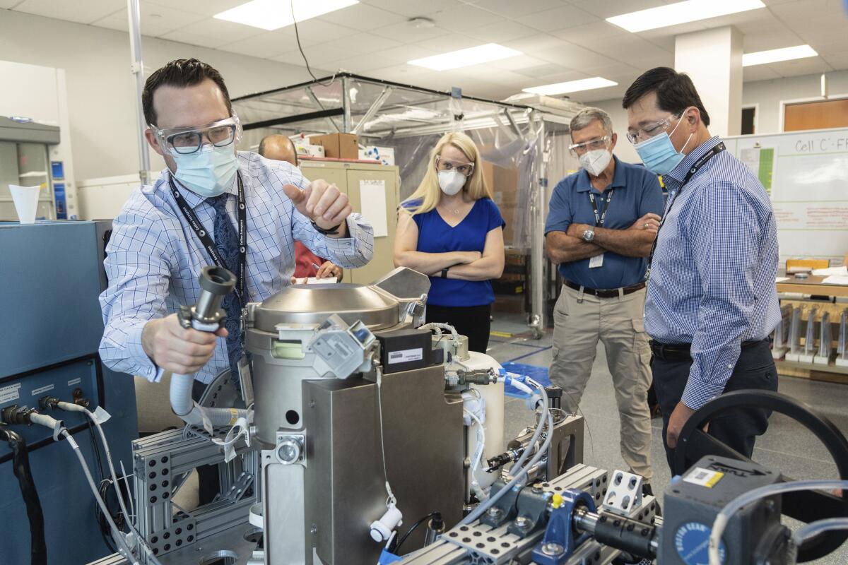 NASA astronaut Kate Rubins and others review a new toilet for use in space