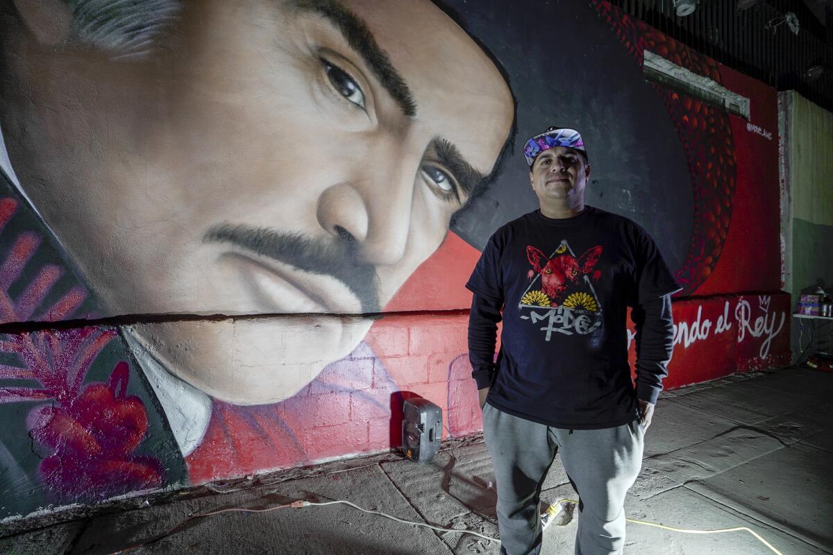 Gerardo Mode Orozco posa frente al mural en homenaje a Vicente Fernández 