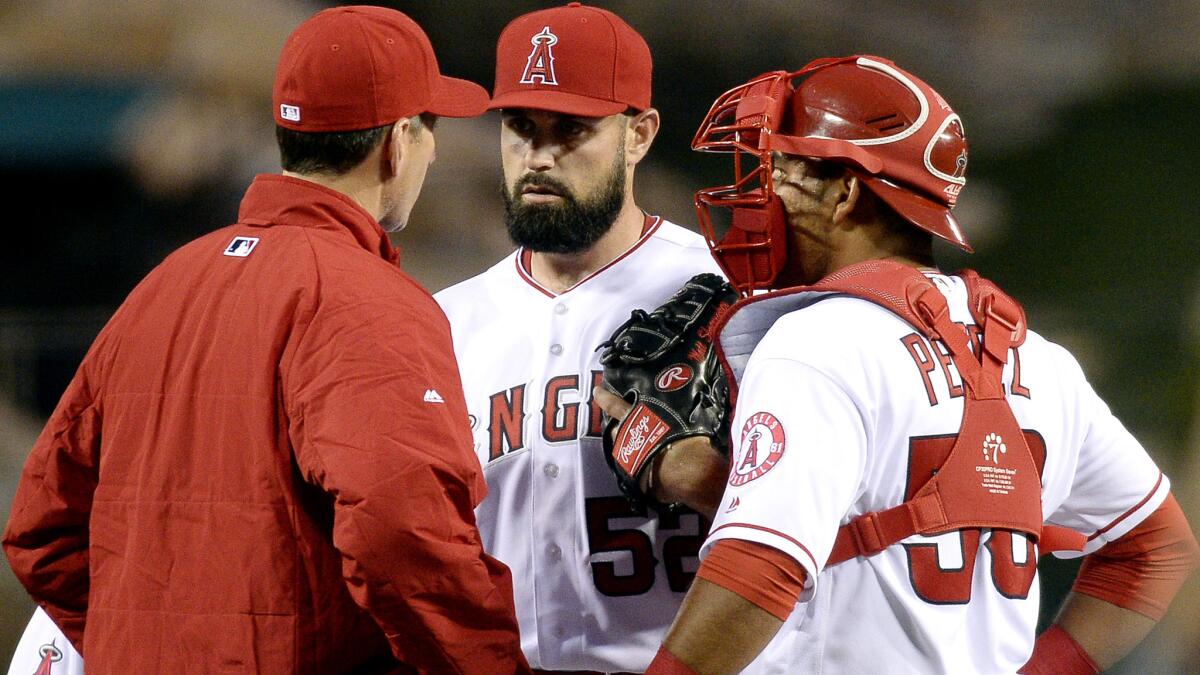 Angels pitching coach Charles Nagy, left, talks to starter Matt Shoemaker, center, and catcher Carlos Perez during the first inning Friday.