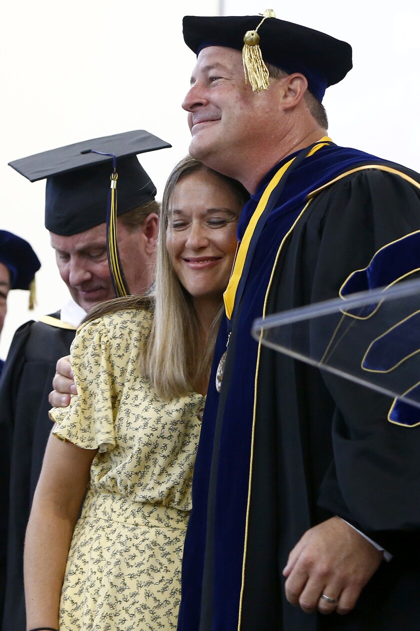 Ryan Hartwig shares a hug with his wife, Jill, as she joins him on stage after his speech during Thursday's ceremony.