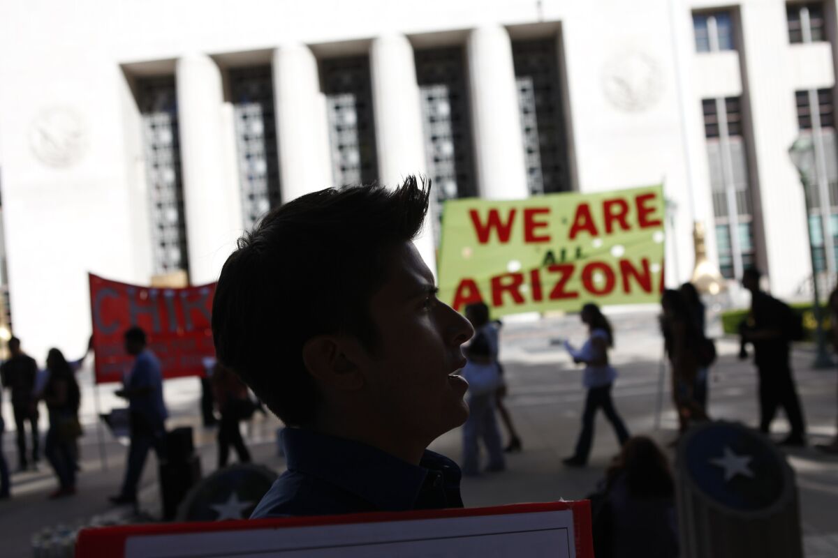 Immigrants' rights supporters march against Arizona's SB 1070 immigration law outside federal court in Los Angeles in 2012.