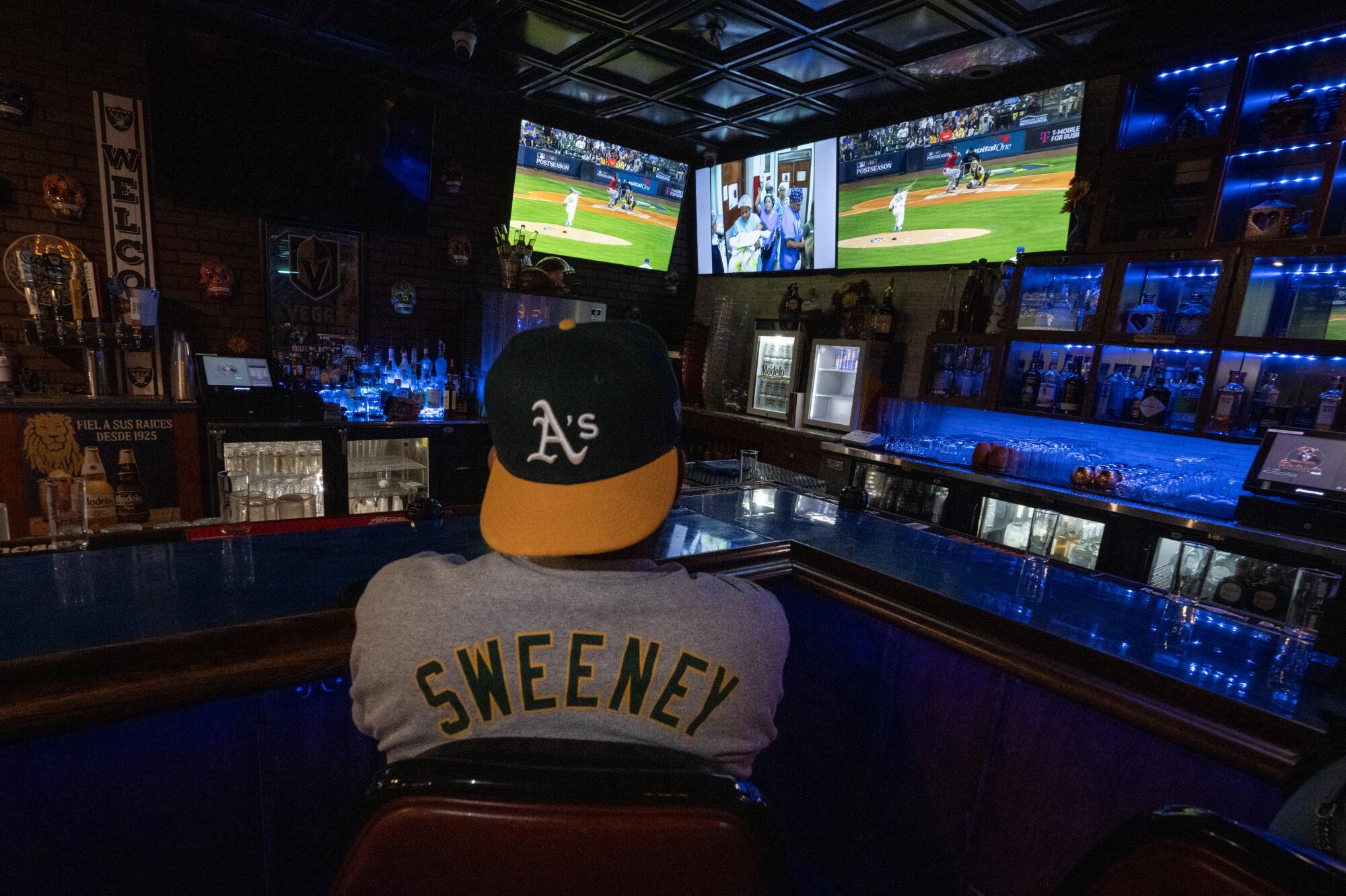 A man in an A's hat watches the game.