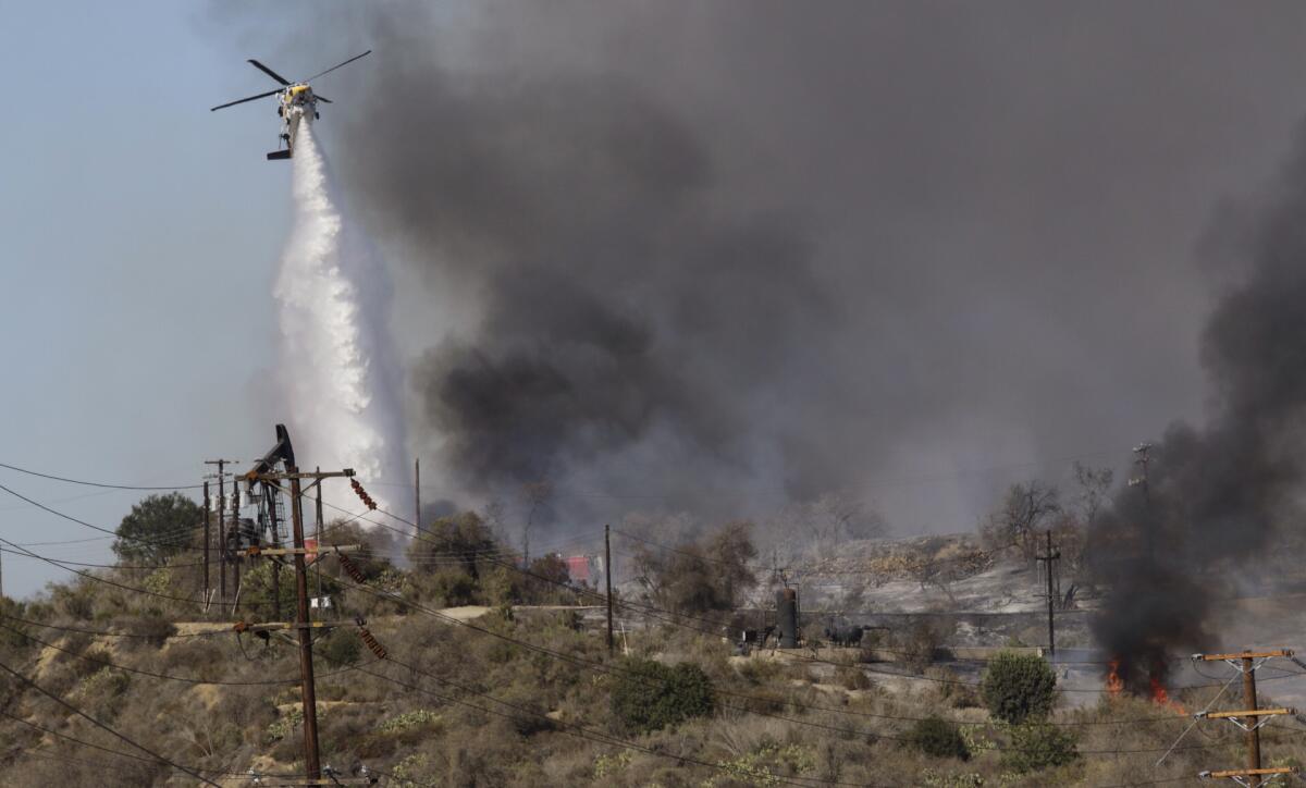 A firefighting helicopter drops water on a fire that broke out in Montebello on Sunday.