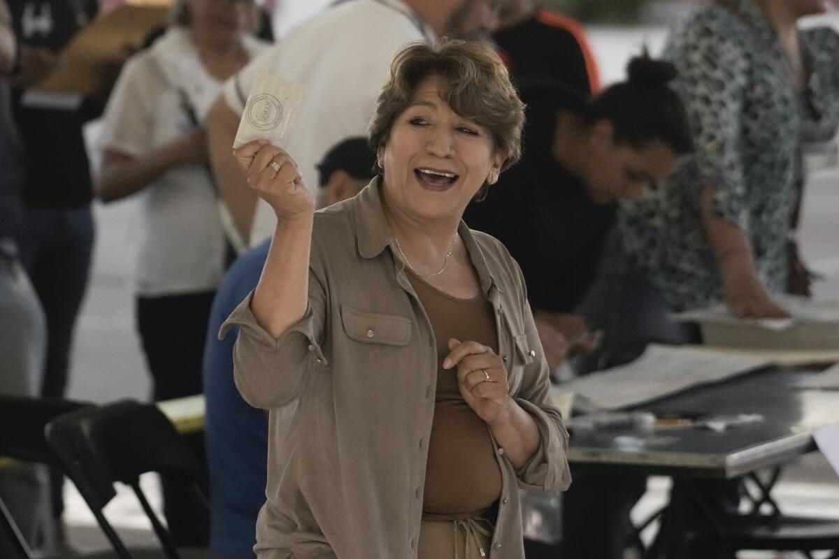 Delfina Gómez holds up her ballot at a polling station