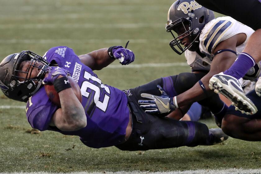 Northwestern running back Justin Jackson (21) falls across the goal line for a touchdown before Pittsburgh linebacker Oluwaseun Idowu can bring him down during the second quarter Wednesday.