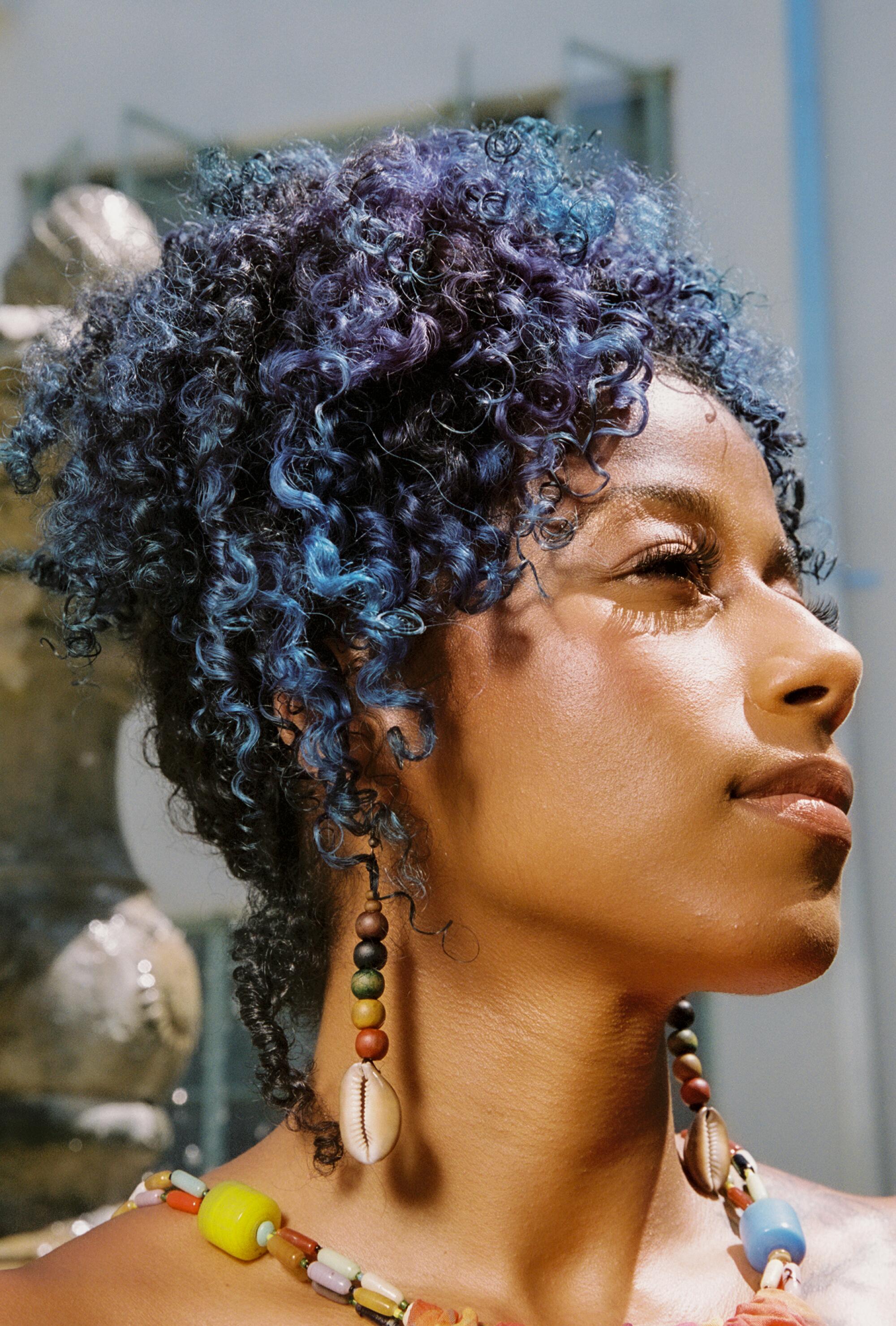 A close-up photo of a woman, chin held high, looking off to her left