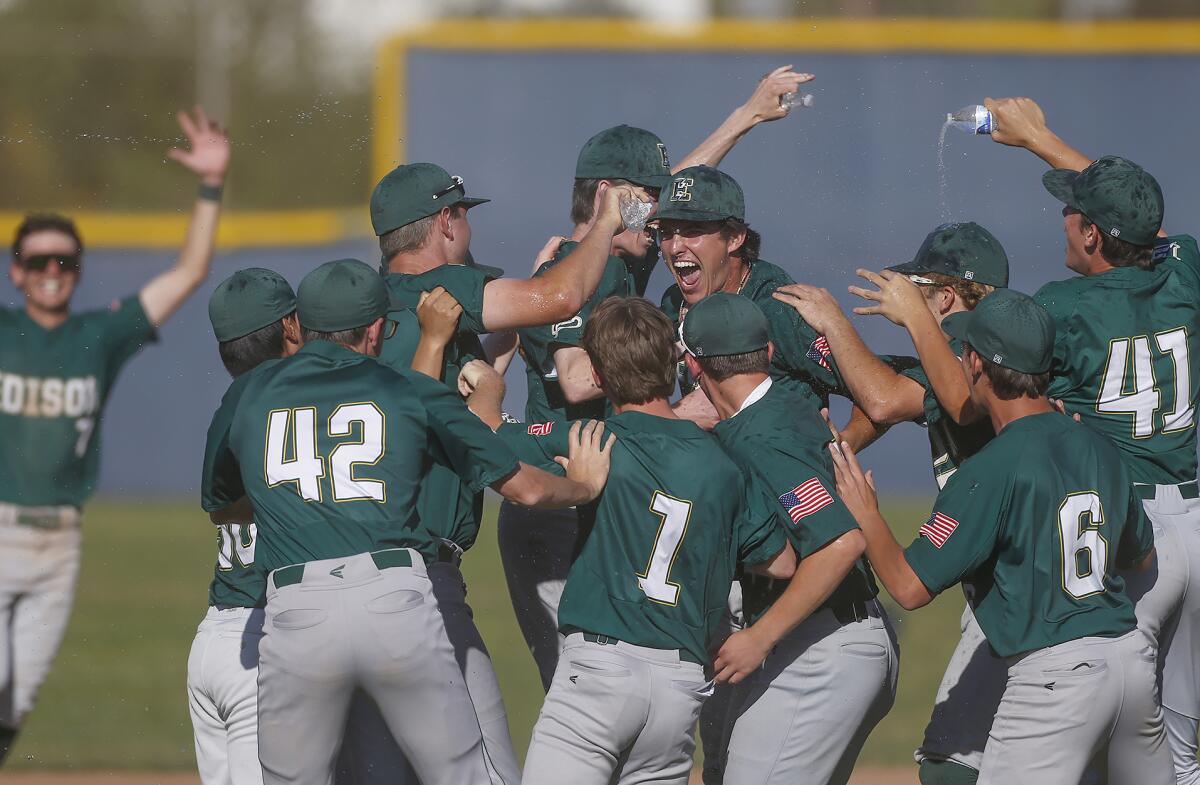 Edison starting pitcher Zack Marker, center with smile, is mobbed by teammates after pitching a shutout during a Wave League baseball game against Newport Harbor on Friday.