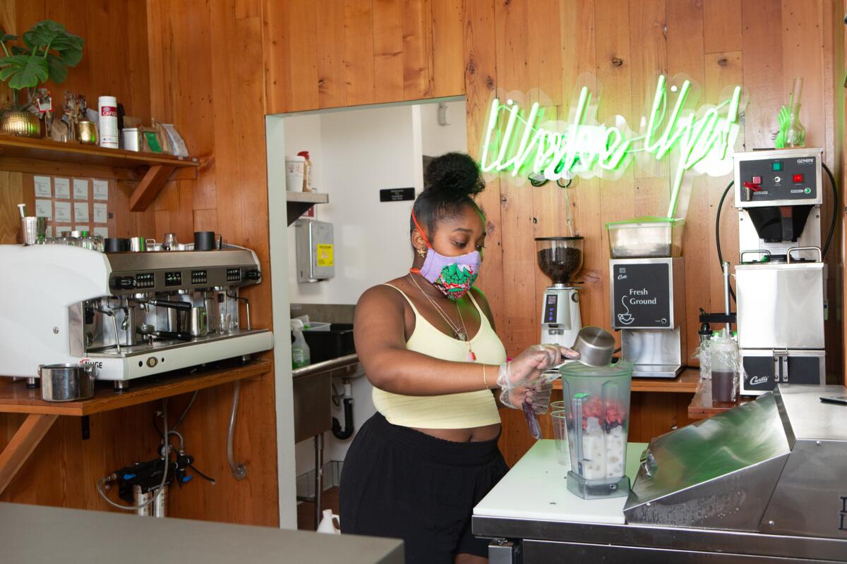 Audrey Webb, 22, a barista at Harun Coffee in Leimert Park, makes smoothies for customers. Webb thinks the "Reopen California" protesters are selfish and was horrified that some compared themselves to civil rights icon Rosa Parks.