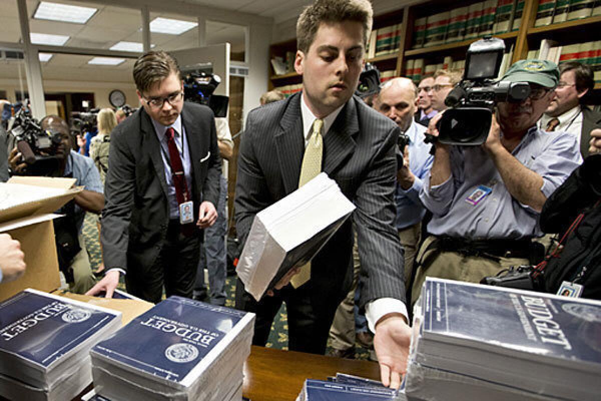 Copies of President Obama's budget plan for fiscal year 2014 are distributed to Senate staff on Capitol Hill.