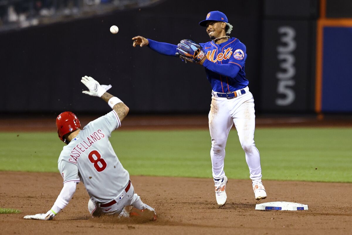 New York Mets shortstop Francisco Lindor throws to first after forcing out Philadelphia Phillies' Nick Castellanos (8) during the fifth inning of a baseball game Saturday, May 28, 2022, in New York. Jean Segura was out at first. (AP Photo/Jessie Alcheh)