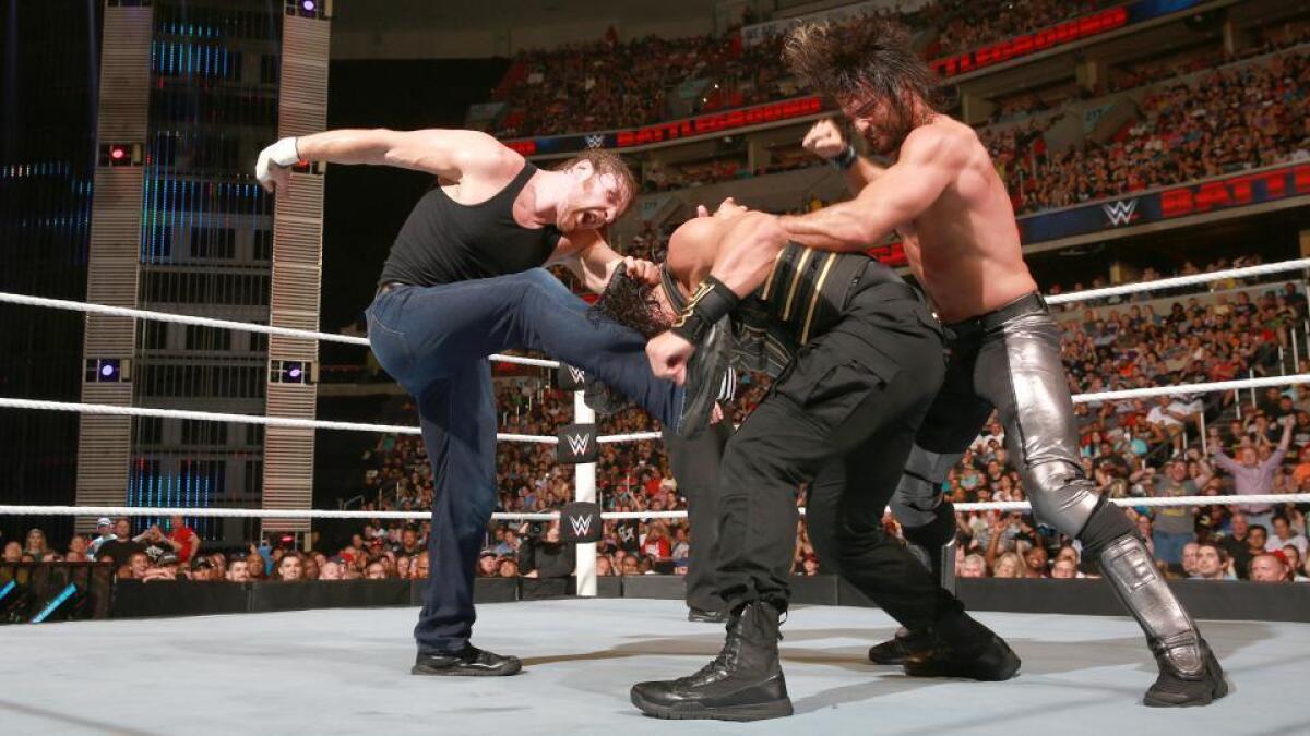 "Essential" in Florida: Dean Ambrose, left, and Seth Rollins, right, gang up on Roman Reigns.