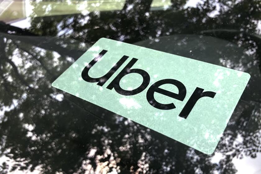 FILE- An Uber sign is displayed inside a car in Palatine, Ill., Monday, May 22, 2023. The Ride-hailing company Uber announced Aug. 24, 2023, that it will raise the minimum age for drivers who will transport others to 25. (AP Photo/Nam Y. Huh,File)