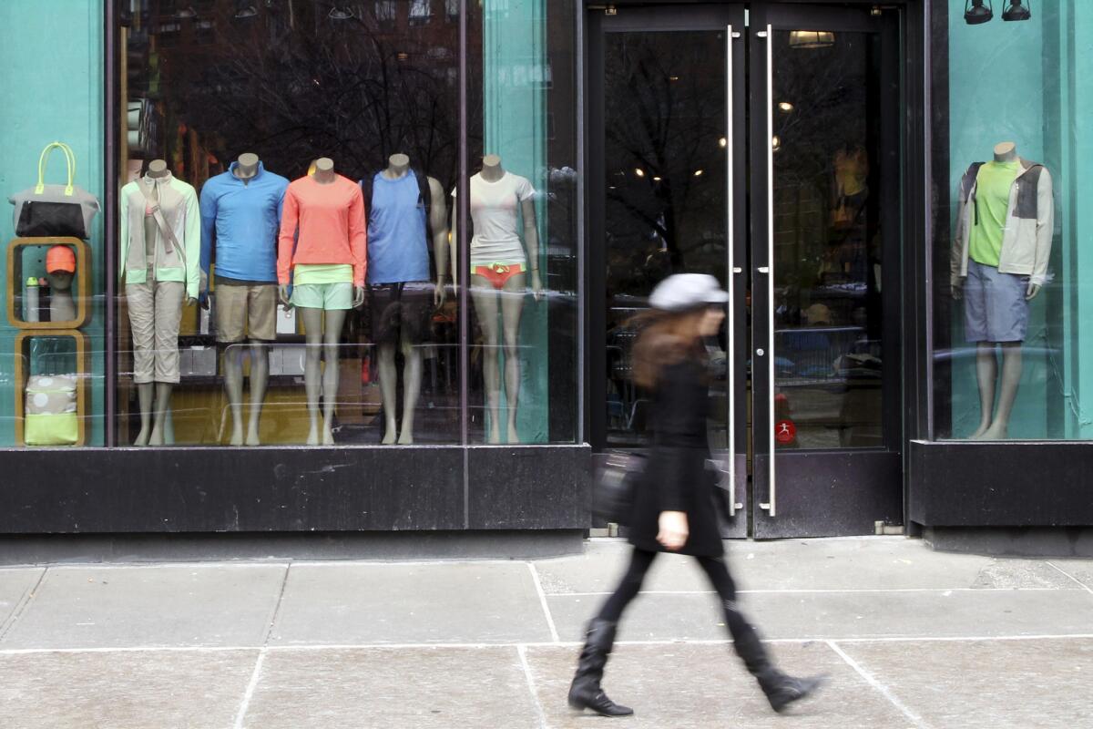 A woman walks past a Lululemon Athletica store.