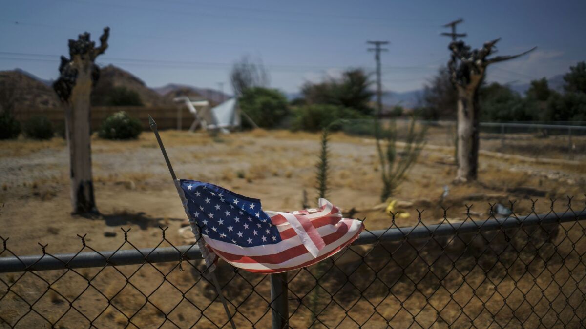 A tattered American flag flutters outside an abandoned property in the South Lake neighborhood that was destroyed by the Erskine fire in Lake Isabella.