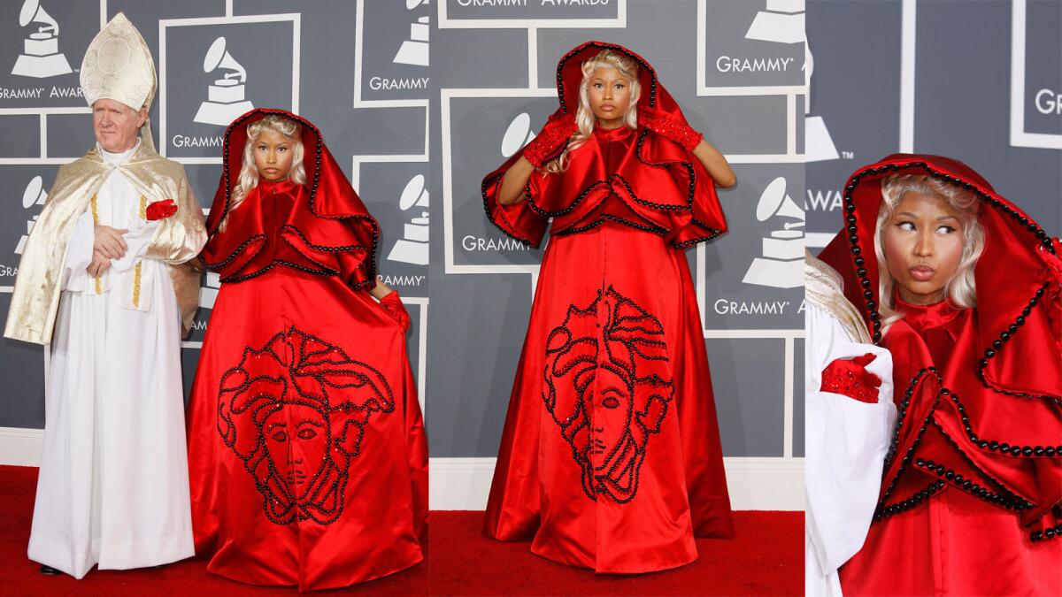Nicki Minaj’s blood-red custom Atelier Versace silk dress and hooded cape ensemble at the 2012 Grammys stuck with us not just because of the Little Red Riding Hood meets Flying Nun vibe but also because she accessorized the look with a guy dressed like the pope.