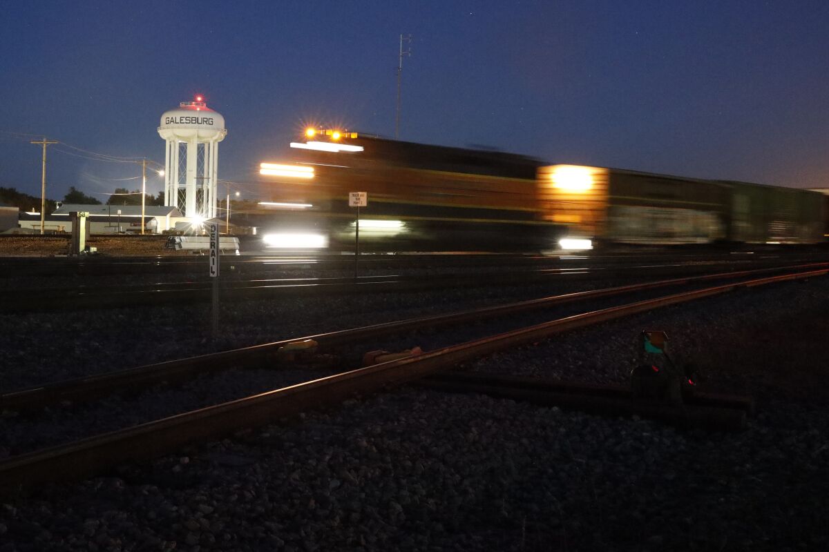 A BNSF freight train passes a Galesburg, Ill., water tower in downtown Galesburg late Wednesday, June 16, 2021. Galesburg, in the heart of the Midwest, the fights in Washington over the filibuster and creating a commission to investigate the events of Jan. 6 seem distant and detached. But in interviews with close to 30 people in Galesburg, conversations are dominated by issues much closer to home, like rising crime, racial strife and whether life can return to an approximation of normal after a deadly pandemic. (AP Photo/Shafkat Anowar)