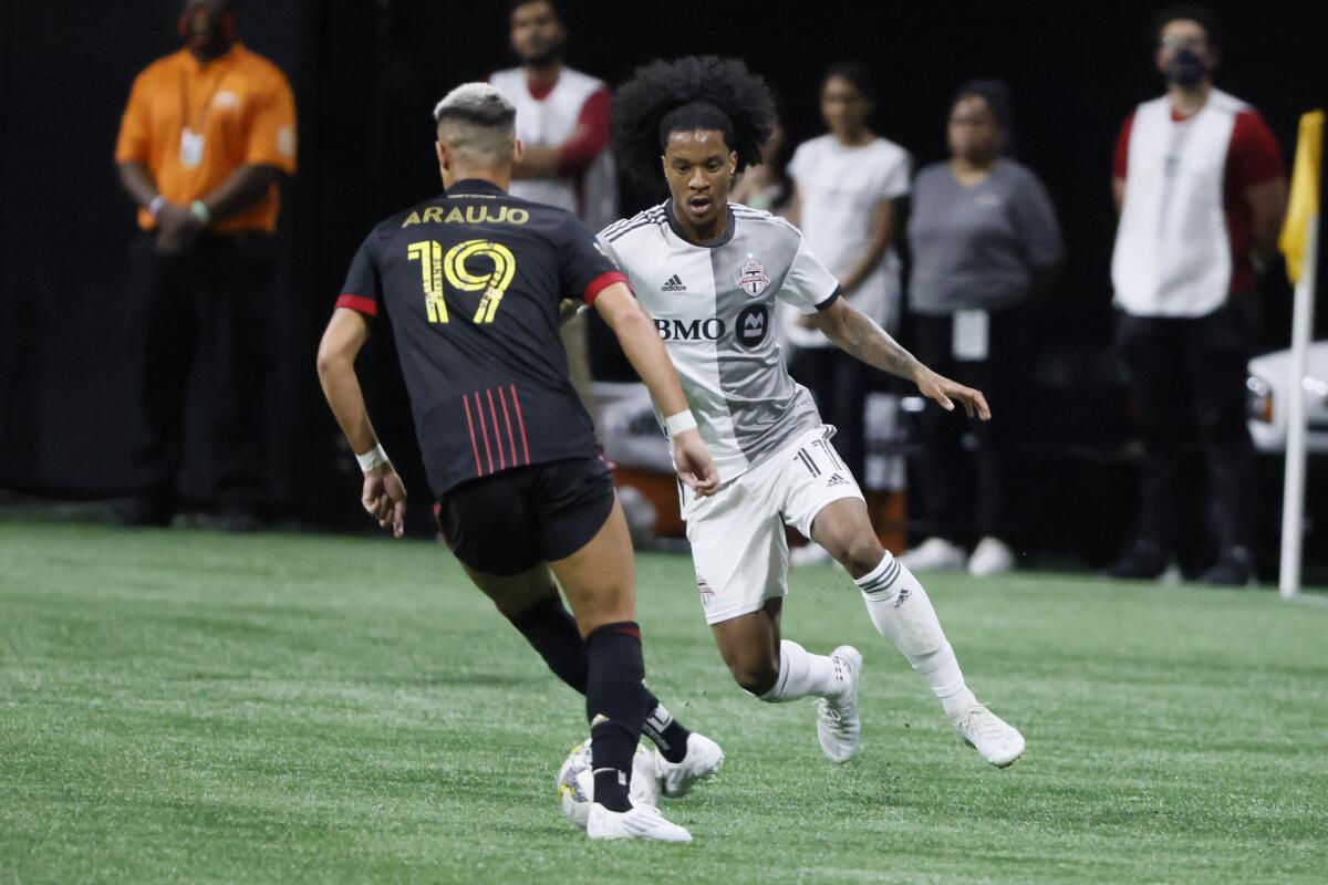 Atlanta United's Luiz Araújo (19) and Toronto FC's Jayden Nelson (11) go for the ball in the first half of an MLS soccer match on Saturday, Sept. 10, 2022, in Atlanta. (AP Photo/Bob Andres)