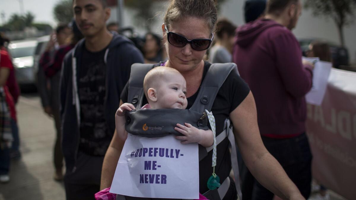 A mother participates in the #MeToo Survivors' March in Los Angeles on Nov. 12 with her 6-month-old daughter.