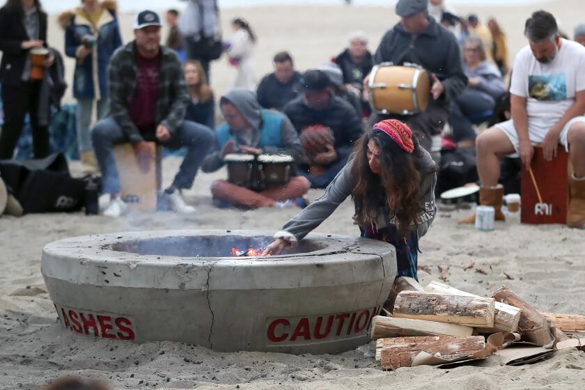 The Laguna Beach city council approved the installation of up to seven wood burning fire pits at Aliso Beach now that the beach it is under local control. Participants of a drum circle gathering use the old fire pits shown above.