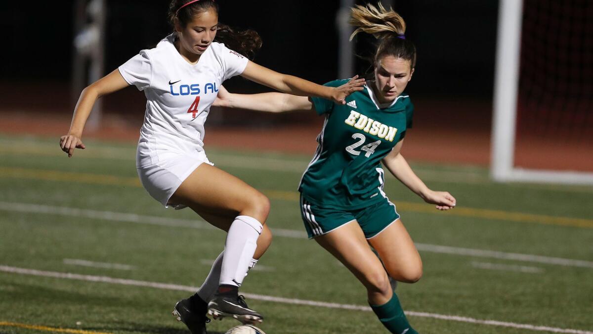 Los Alamitos' Alyssa Mendoza battles for the ball against Edison's Madi Macias during a Sunset League game on Tuesday.