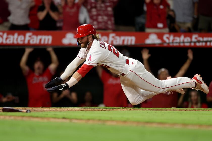 Angels' Trey Cabbage scores the winning run in the 10th inning against the Houston Astros on July 15, 2023, in Anaheim.
