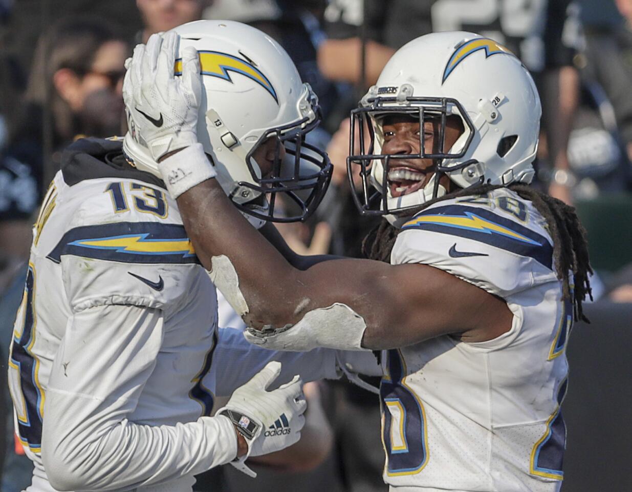Chargers running back Melvin Gordon III celebrates with teammate Keenan Allen after scoring a touchdown early in the third quarter at Oakland-Alameda County Coliseum on Sunday.