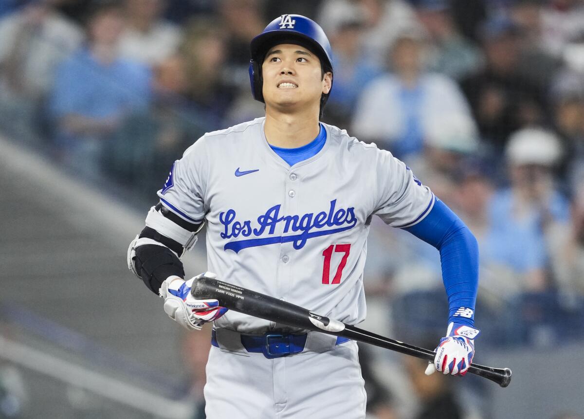Dodgers slugger Shohei Ohtani grimaces after trying to check his swing Sunday.