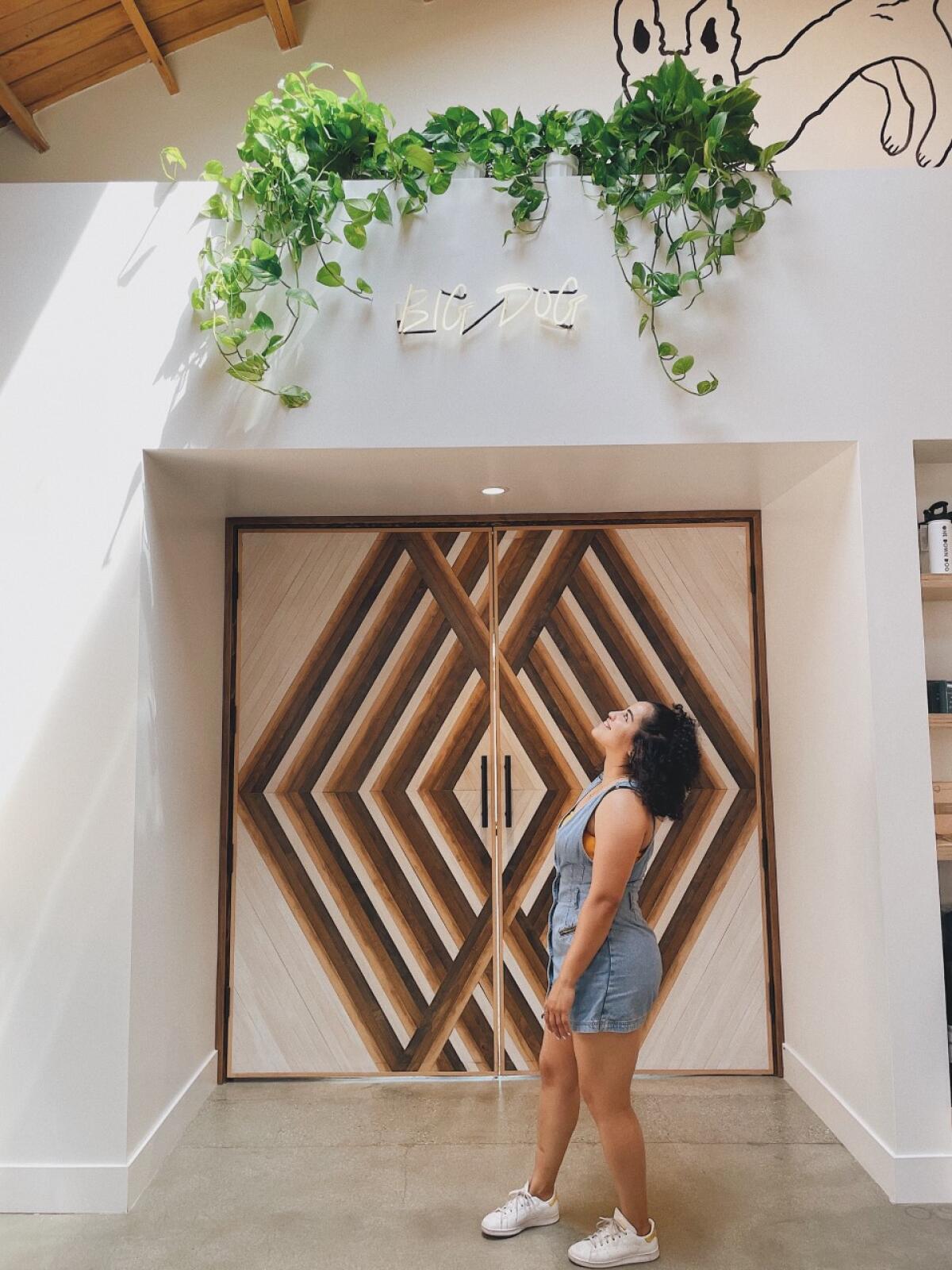 Lola Morales poses in front of One Down Dog, a yoga studio she helped decorate.