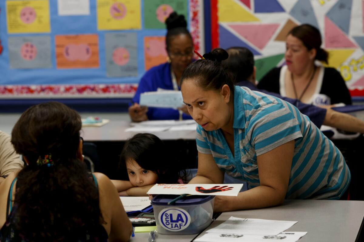 Erica Sol, right and daughter Gudalupe Curiel, 3, listen during a screening event for Covered California and Medi-Cal enrollees at Our Lady of Peace Parish in North Hills. Obamacare sign-up events are picking up as the March 31 open-enrollment deadline approaches.