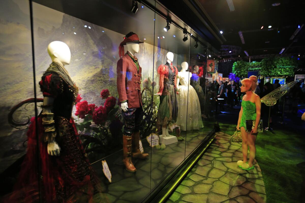 Marina Voronina of Russia, dressed as Tinker Bell, looks at costumes for "Alice in the Looking Glass" at Disney's D23.