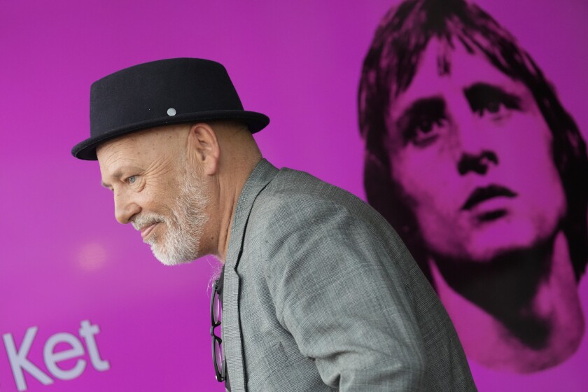Director and writer Tom de Ket passes a screen with a picture of Johan Cruyff, during a presentation of "14 The Musical" in Leusden, Netherlands, Friday, June 11, 2021. On the opening day of the pandemic-delayed European 2020 Soccer Championship, the cast and crew of "14 The Musical", referring to Cruyff's shirt number, raised the curtain on the new musical eulogizing the country's most famous footballing son, Johan Cruyff. (AP Photo/Peter Dejong)
