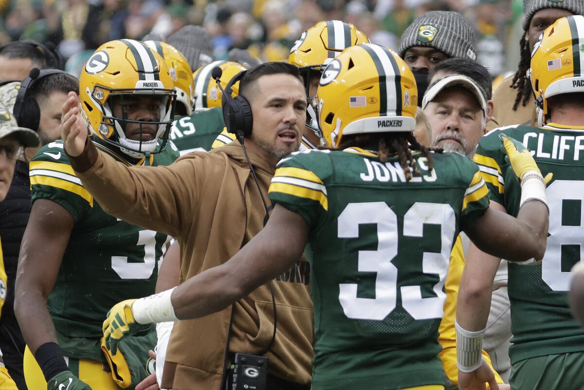 Packers running back Aaron Jones (33) celebrates his touchdown run with coach Matt LaFleur.