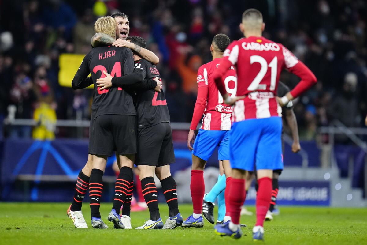 AC Milan players celebrate next to dejected Atletico players after winning 1-0 during a Group B Champions League soccer match between Atletico Madrid and AC Milan at the Wanda Metropolitano stadium in Madrid, Spain, Wednesday, Nov. 24, 2021. (AP Photo/Manu Fernandez)