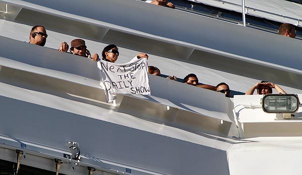 A passenger aboard the Carnival Splendor waves a message as the cruise ship arrives in San Diego Harbor.