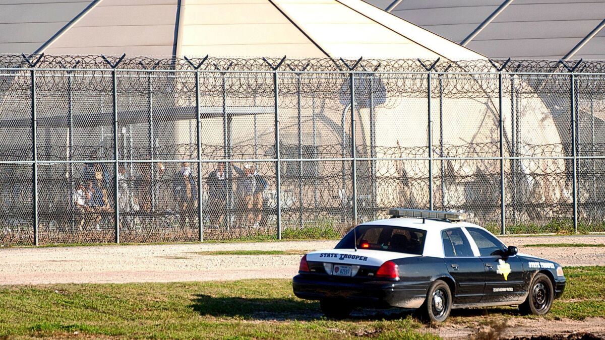 Prisoners stand at the western fence as law enforcement officials converge on the Willacy County Correctional Center in Raymondville, Texas, in response to a prisoner uprising in 2015.