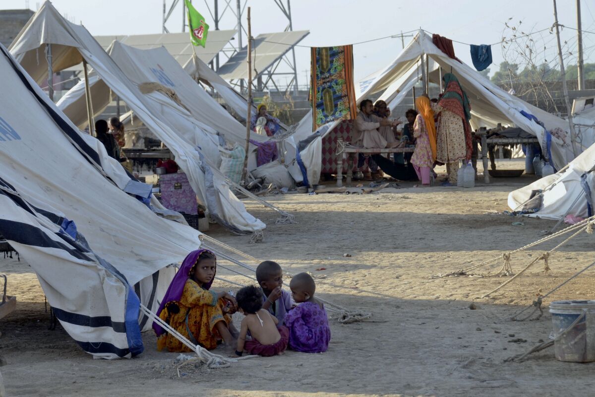 Children play outside their tent at a relief camp in Pakistan