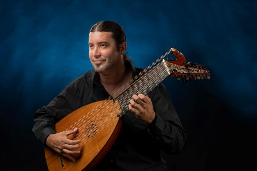 San Diego musician Eric Dickerson with a lute, one of the baroque-era instruments he plays.
