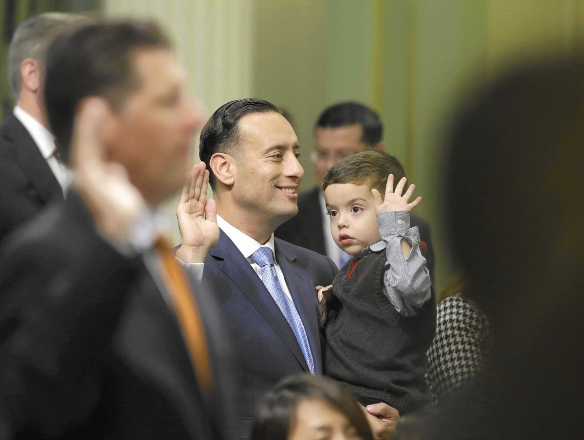 Assemblyman Roger Hernandez (D-West Covina) carries 4-year-old nephew Nathan Rogelio Hernandez while taking the oath of office.