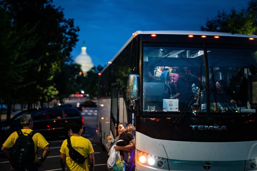 WASHINGTON, DC - AUGUST 11: Migrants disembark a bus from Texas within view of the U.S. Capitol on Thursday, Aug. 11, 2022 in Washington, DC. Since April, Texas Governor Greg Abbott has ordered over 150 buses to carry approximately 4,500 migrants from Texas to Washington, DC, to highlight criticisms of US President Biden's border policy. (Kent Nishimura / Los Angeles Times)