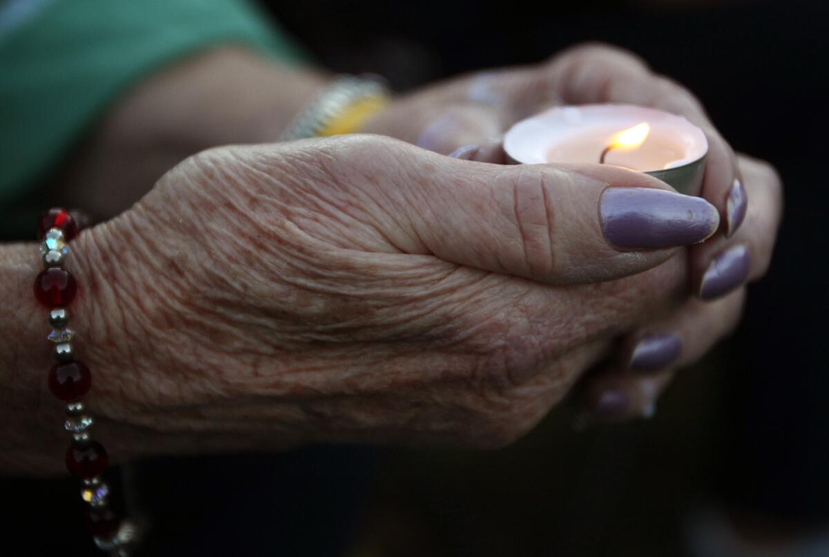 A woman holds a candle during a vigil for James Foley in his hometown of Rochester, N.H., on Saturday.