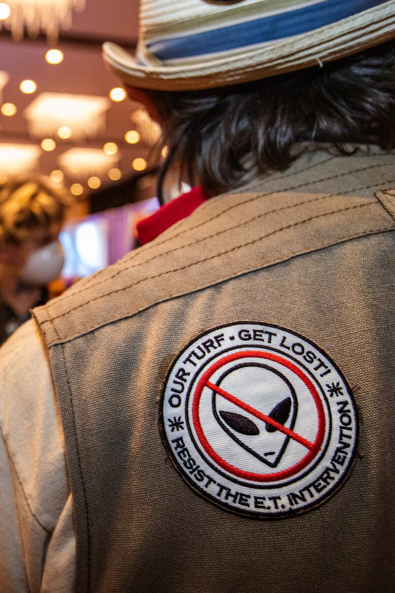 A close up of a man's shoulder, with a patch that reads: "Our turf, get lost, resist the ET intervention."